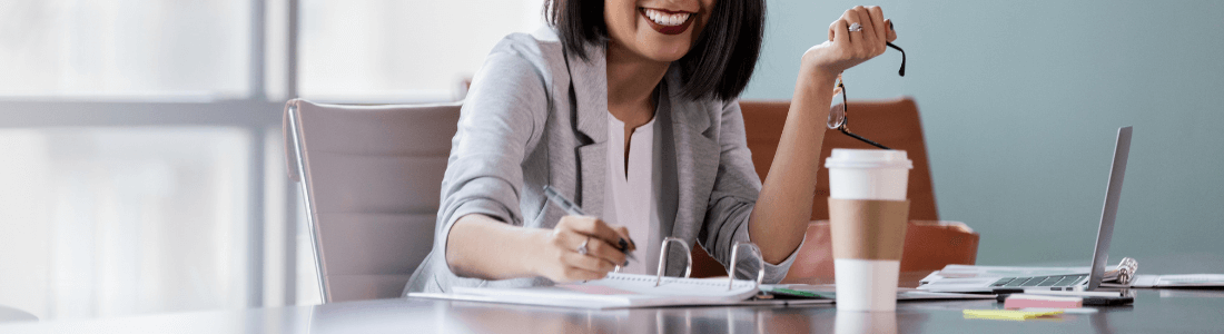 smiling woman behind desk enjoying her job