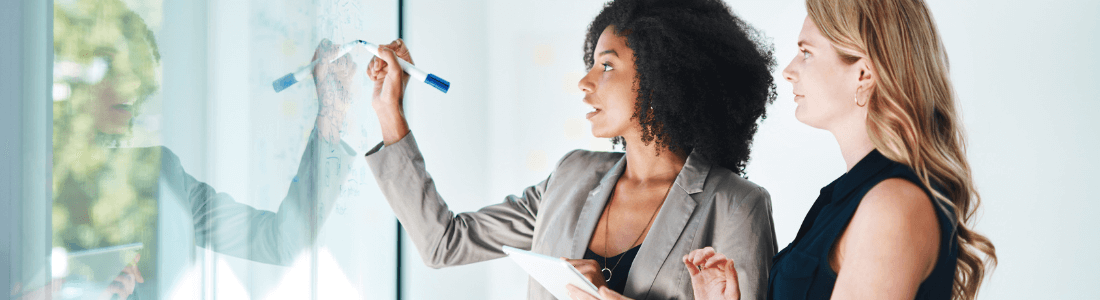 two women in front of board designing brand image