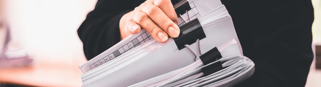 woman holding stack of documents with regulations